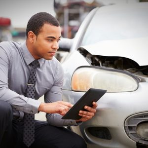 insurance adjuster examining car