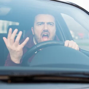 an angry driver throwing up their hand