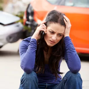 a woman involved in a car accident calls a car accident lawyer
