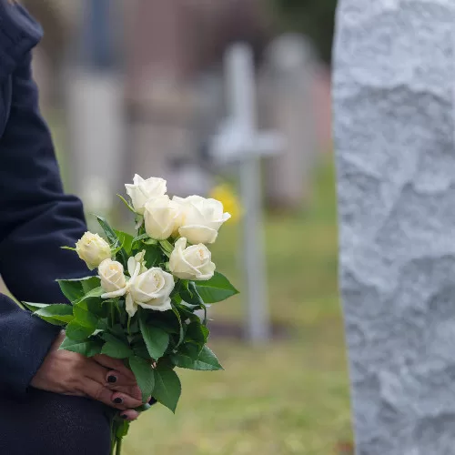 st. louis woman leaving flowers at a grave